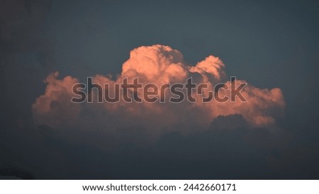 A giant cloud floating in sky during sunset 