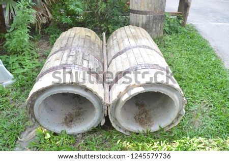 Giant concrete water pipes on the evergreen lawn beside the house outdoor being prepared for the construction to help make effective drainage system and protect flooding problem Stock fotó © 