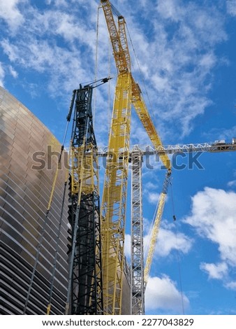Giant construction cranes used in the construction of the exterior facade of a modern football stadium, Madrid, Spain.