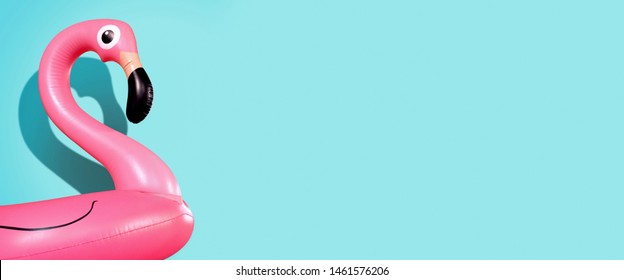 Giant inflatable Flamingo on a blue background, pool float party, trendy summer concept, banner background with copy space