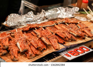 Giant Japanese Grilled Eels Fish (Anguilla Japonica) For Sale With Japanese Price Label At Kuromon Ichiba Market, Osaka, Japan. Japanese Grilled Eels Fish Are Luxury And Expensive Of Japanese Food.