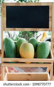 Giant Mangoes On Wood Display Stand With Chalkboard Header.