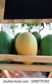 Giant Mangoes On Wood Display Stand With Chalkboard Header.