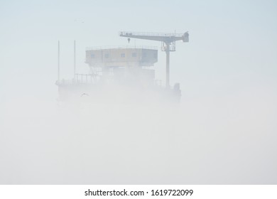 Giant portal crane peering through the fog