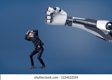 A Giant Robotic Hand Is Ready To Hit A Tiny Scared Businessman With A Fist. Dangerous Technologies. Business And Technical Progress. Science And Entrepreneurship.