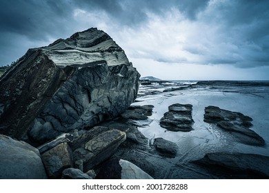 Giant rock formations and ocean pools on stormy day