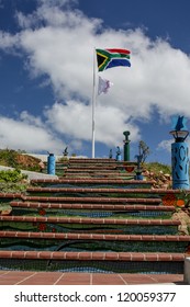 A Giant South African Flag And A White Flag With Pink Ribbon Waving Over The City Of Port Elizabeth Around The Famous Lighthouse Area