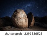 Giant split rock with a sky fall of stars behind it at Karlu Karlu (the Devils Marbles) in Northern Territory, Australia