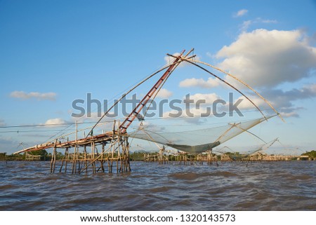 Giant square dipnets for trapping fish in the wavy sea on blue sky background