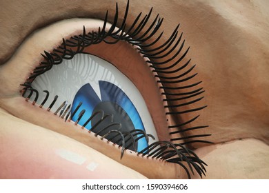 A Giant Statue Of A Blue Cartoon-style Eye With Long Eyelashes 