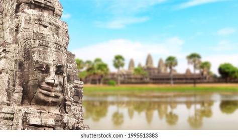 Giant stone face in Prasat Bayon Temple on blue sky background. Horizontal banner with famous landmark Angkor Wat complex, khmer culture, Siem Reap, Cambodia