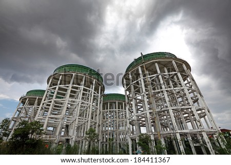 Giant water tower against a dramatic raincloud. 