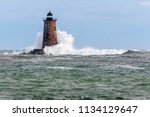 A giant wave from an unusual high tide breaks around Whaleback lighthouse in Maine.