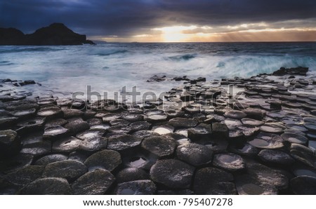 Giant's Causeway, North Ireland, UK (Winter)
Fierce waves batter the iconic coastline of North Ireland during a storm. In the distance, sunrays are released as the storm clouds start dispersing.