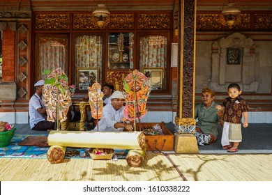 GIANYAR/BALI-AUGUST 14 2019: A Young Balinese Child Watching A Shadow Play Accompanied By His Grandfather. Wayang Kulit Or Shadow Puppets Is One Of Balinese Arts That Is Continuously Preserved