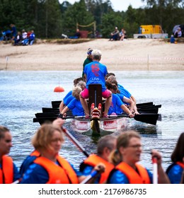 Gifhorn, Germany, July 10, 2022: Frontal View Of Moving Dragon Boat In Which Rowers Are Dressed With Blue Shirts