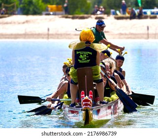 Gifhorn, Germany, July 10, 2022: Frontal View Of Moving Dragon Boat In Which Rowers Are Dressed As Busy Bees