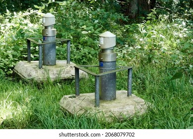 Gifhorn, Germany, September 25, 2021: Concreted Well Heads Of Groundwater Monitoring Wells With Steel Collision Protection In A Forest