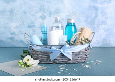 Gift Basket With Cosmetics, Flowers And Envelope On Color Background