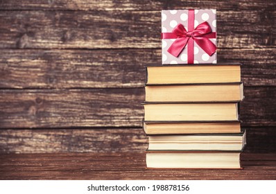Gift and books on wooden table.