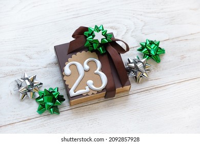 Gift Box With 23 Number And Festive Bows On White Wooden Background. 23 February Holiday, Fatherland Defender Day Concept. Gift For Man, Brutal Style. Top View