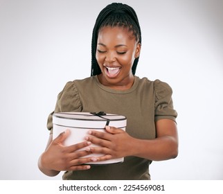 Gift, box and black woman on studio background, present or smile. Happy female, package and surprise with ribbon for birthday, excited celebration and wow product of promotion, happiness and giveaway - Shutterstock ID 2254569081