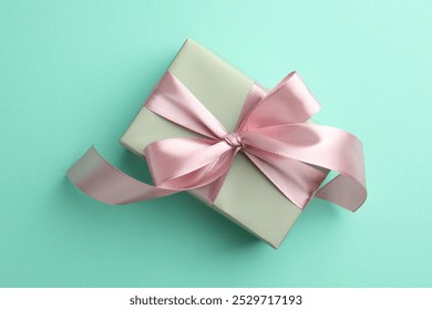 Gift box with bow on turquoise background, top view - Powered by Shutterstock