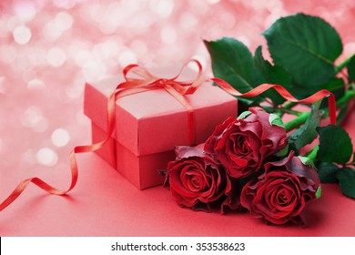 Gift Box With Bow Ribbon And Red Roses Flowers On Holiday Background For Valentines Day