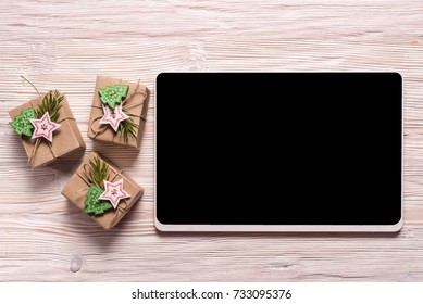 Gift box and digital tablet on wooden background