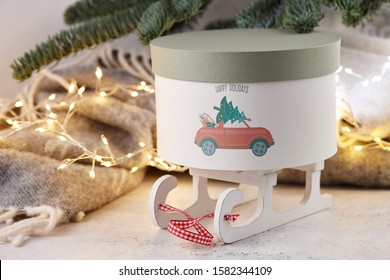 Gift Box With Holiday Car Print Under Christmas Tree On Wool Blanket And Lights Background