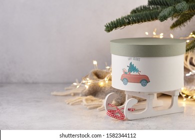 Gift Box With Holiday Car Print Under Christmas Tree On Wool Blanket And Lights Background, Copy Space