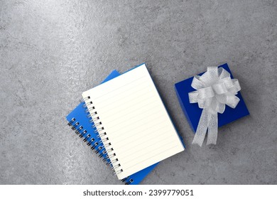 Gift box with note book on stone texture background. Planning. Flat lay. Top view.