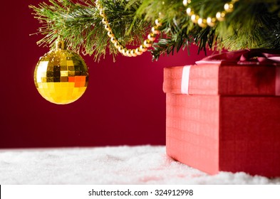 gift box on snow under christmas tree