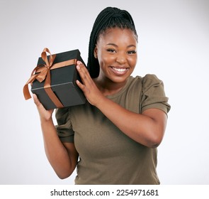Gift, box and portrait of woman on studio background, package or smile. Happy black female, present and surprise with ribbon, birthday celebration and excited giveaway, product promotion or happiness - Shutterstock ID 2254971681