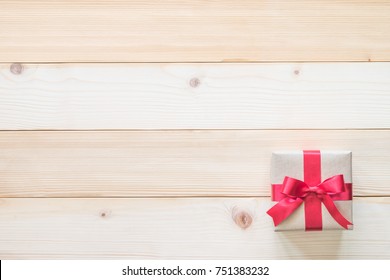 Happy Boxing Day Messages, Wishes, Quotes, And Images 59 Gift box present with red bow ribbon and brown krafts wrapping paper on white pine wood backdrop for Christmas boxing day, winter xmas holiday seasonal celebration and wedding present background