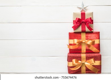 Happy Boxing Day Messages, Wishes, Quotes, And Images 9 Gift box present stack in Christmas tree shape with red-gold luxury ribbon, star top on white pine wood backdrop for Xmas boxing day and winter holiday seasonal celebration background