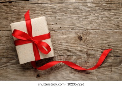 Gift Box With Red Bow On Wood Background