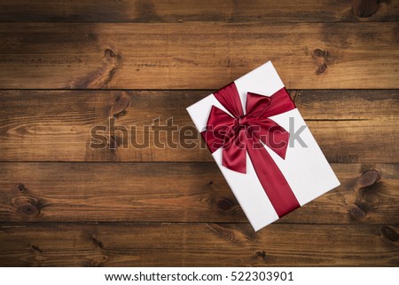 gift box with red bow on wood table