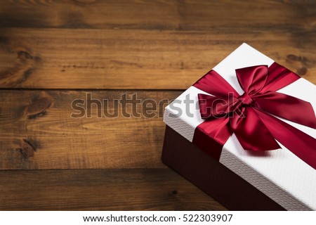 gift box with red bow on wood table