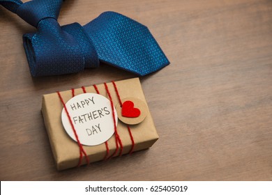 Gift box with red heart and ribbon, blue tie and Father's day card . Striped tie near present box. Best quality gifts for dads. Happy father's day idea, sign, symbol. holiday background - Powered by Shutterstock