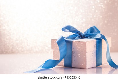 Gift Box With Ribbon On White Glitter Background