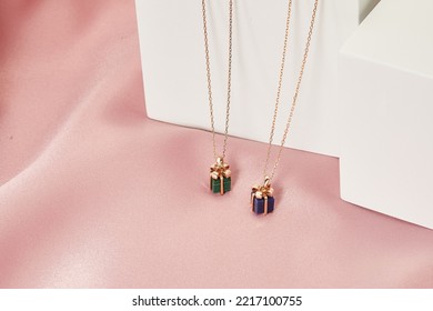 Gift Box Shape Pendant Gold Necklace On White And Pink Background. Romantic Jewelry. Advertising Still Life Product Concept For Valentines Day