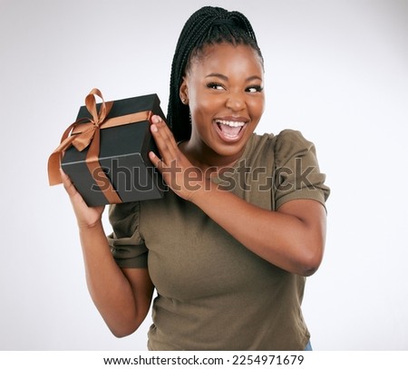 Gift, box and woman guess in studio with package, smile and celebration. Happy, curious and black female with present, surprise and ribbon on background, birthday and giveaway of product promotion