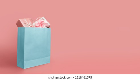 Gift Boxes In Blue Paper Shopping Bag On Isolated Pink Background With Copy Space. Black Friday, Sales, Giving Gift For Christmas And New Year 2019.