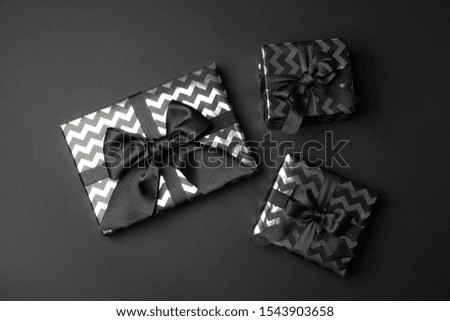 Gift boxes with bow on black background. Black Friday sale