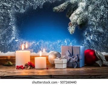 Gift boxes, candle lights and frozen window. Christmas background. - Powered by Shutterstock