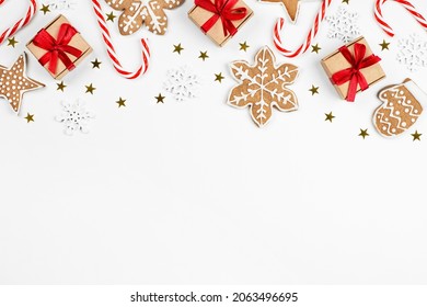 gift boxes, candy cane, gingerbread cookie, snowflakes and confetti on a light background, christmas composition