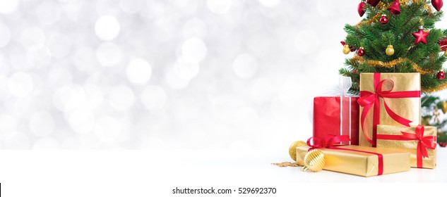 Gift Boxes And Colorful Decorated Christmas Tree On White Bokeh Background, Panoramic Banner With Copy Space