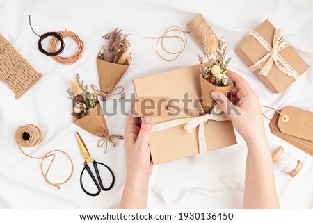 Gift boxes in craft paper and natural decorations, creative and zero waste holidays present wrapping. Womens day, mothers day, easter greeting concept. Top view, flat lay