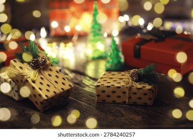 Gift boxes with a large red bow  against a background bokeh of twinkling party lights. Luxury New Year gift. Christmas gift. Christmas background with gift box. Christmastime celebration